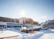 Moderne Hotelanlage Das Hohe Salve im verschneiten Winter bei strahlendem Sonnenschein und blauem Himmel.