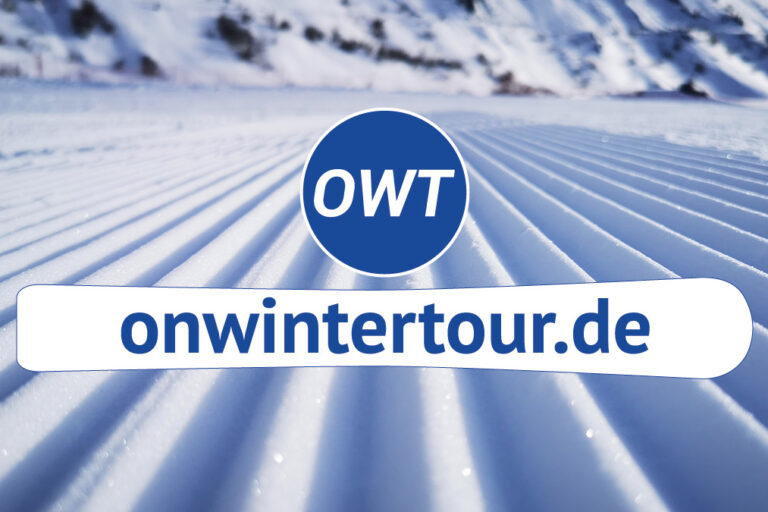 Banner mit dem Logo „OWT“ und der Website „onwintertour.de“ vor einer frisch präparierten Skipiste.